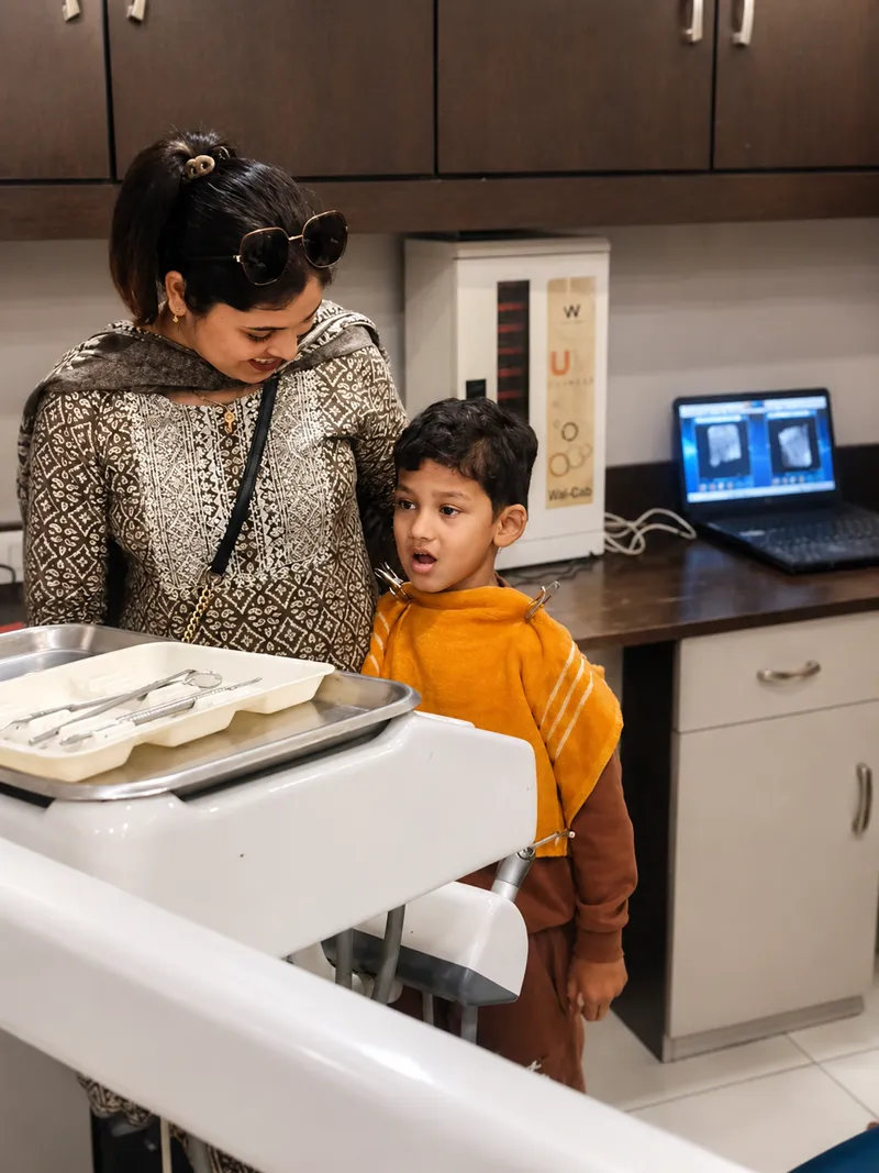 Parent and child reviewing digital dental X-rays on a laptop at Sanjeevani Dental Clinic